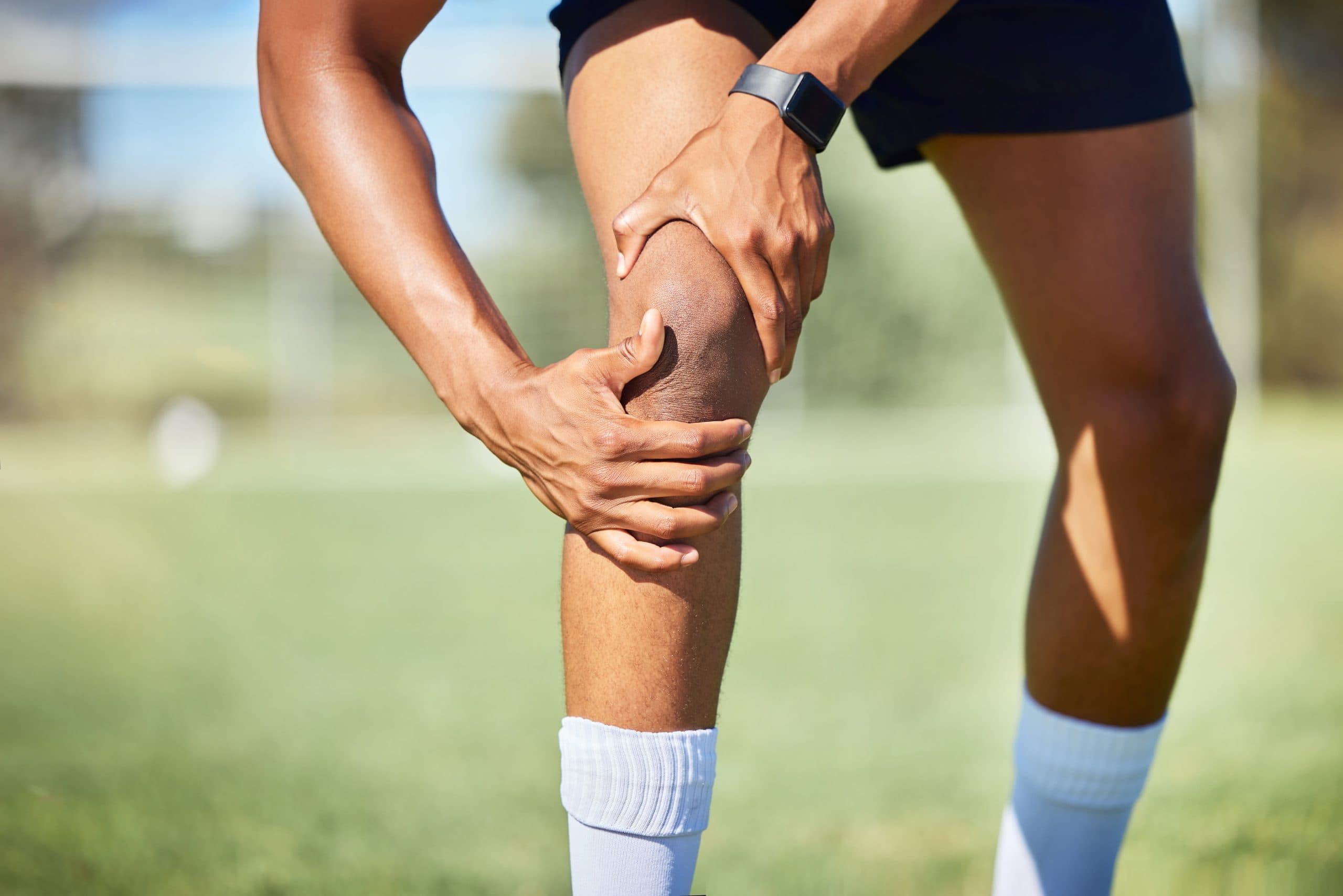 Athlete grasping their knee after an ACL injury