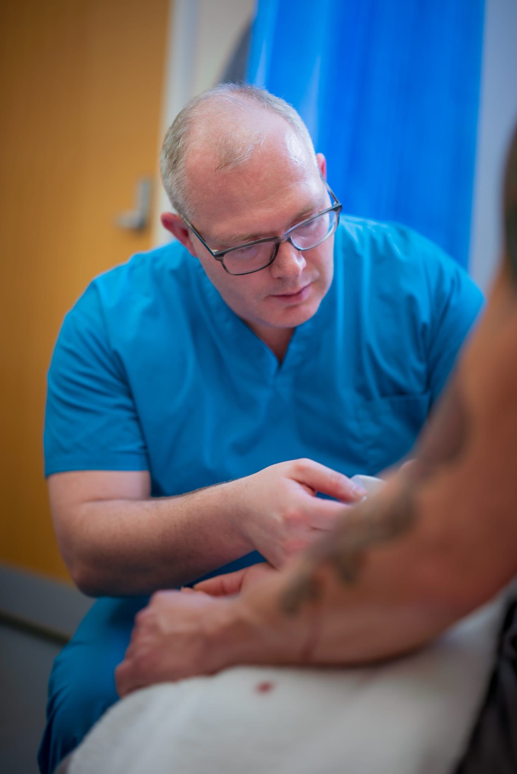 Clinician examining a patient's elbow