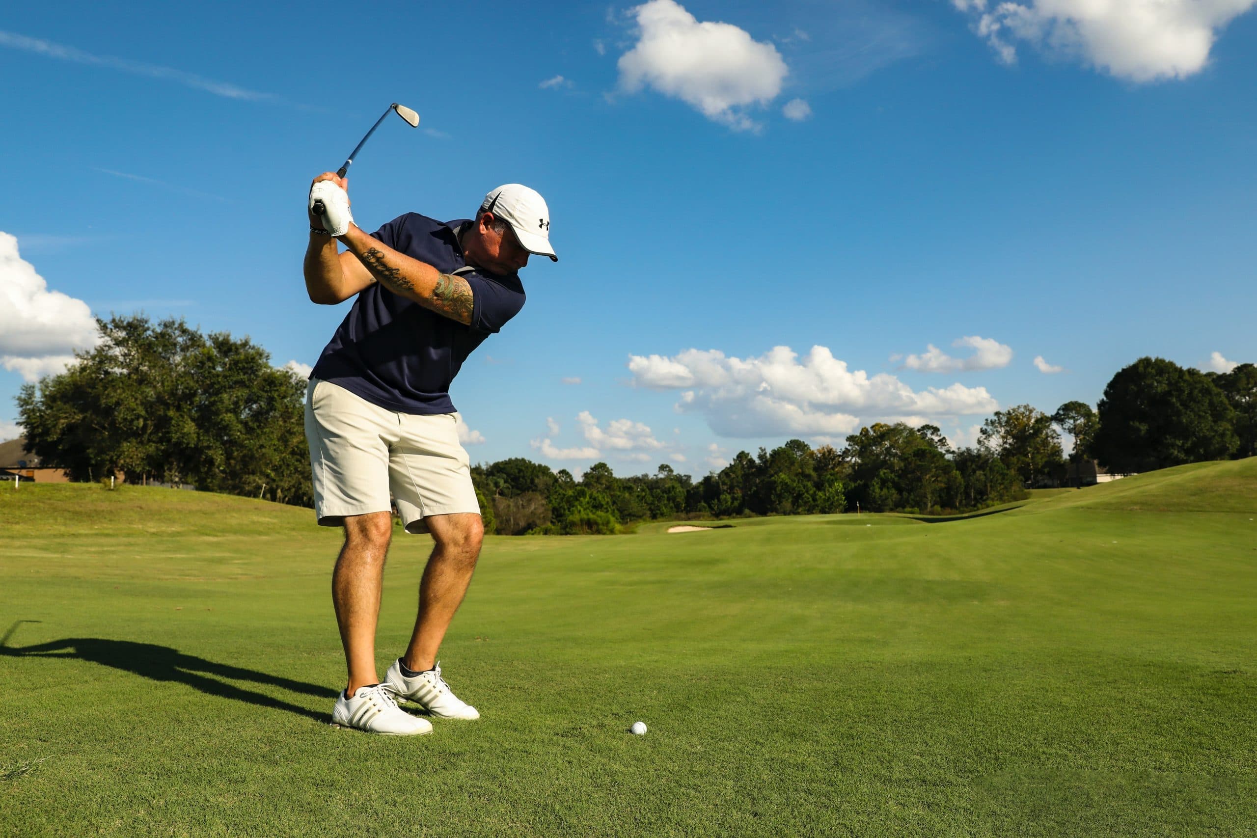 Golfer swinging on green fairway